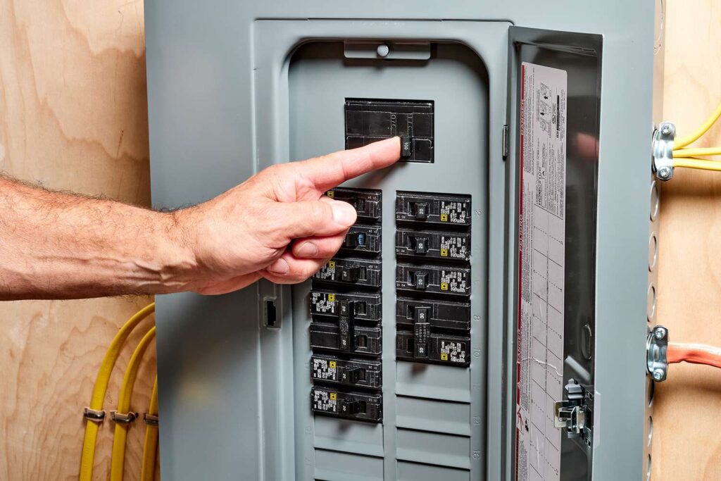 How Much Does an Electrician Cost to Fix a Breaker? Electrician testing circuit breaker with multimeter - breaker repair cost