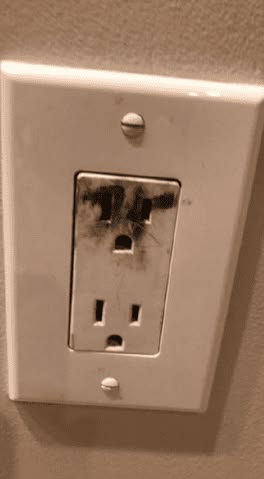 warning signs your electrical outlet is about to catch fire: hot outlet, flickering lights, buzzing sounds, scorch marks, frequent breaker trips, and fishy odor. Includes NFPA statistic that electrical fires cause 51,000 home fires annually in the U.S. and CTA to call a licensed electrician immediately.