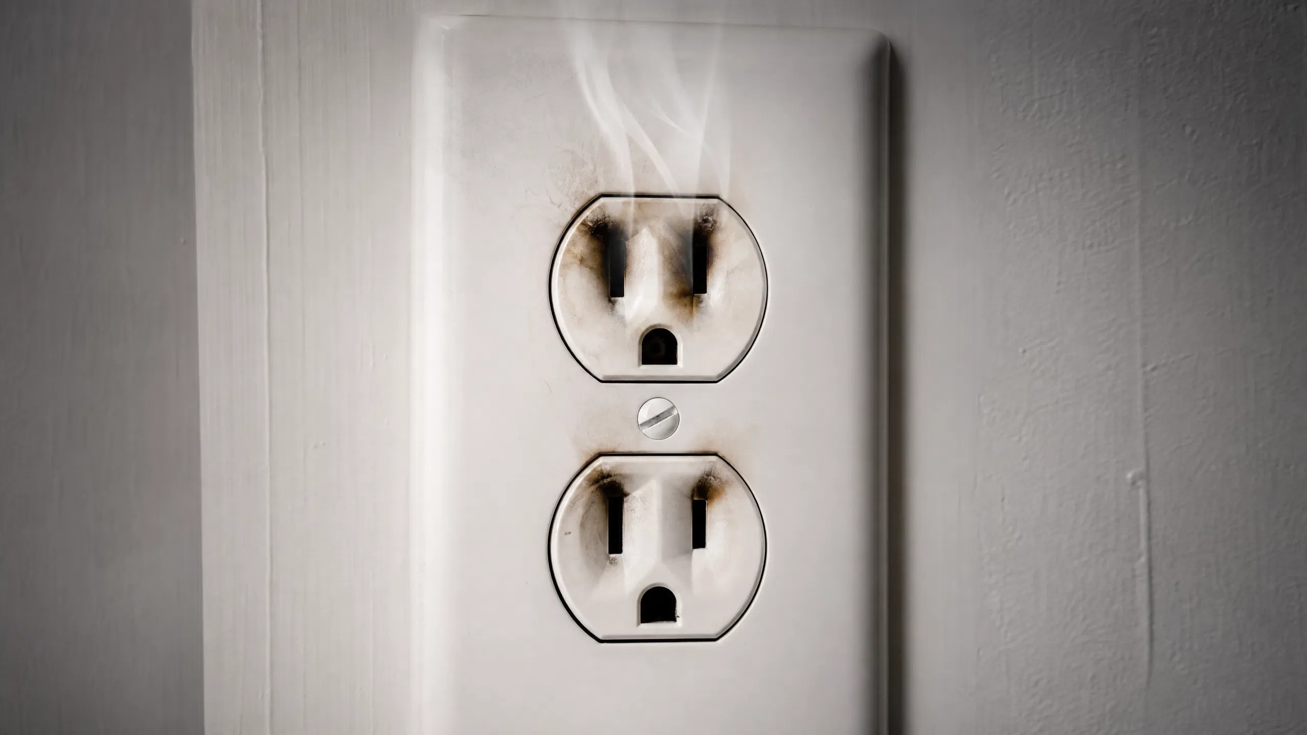 Burning Smell from Outlet with Nothing Plugged In? Your Nationwide Urgent Safety Guide Burning smell from outlet with nothing plugged in showing scorch marks and smoke