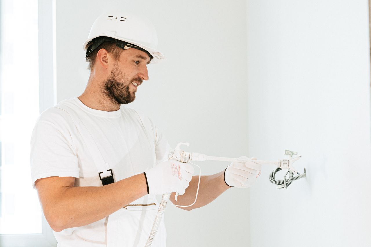 menu-01 Electrician wearing safety gear installing wiring in a new building.